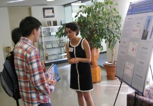 Two students talk in front of CalDay presentation posted