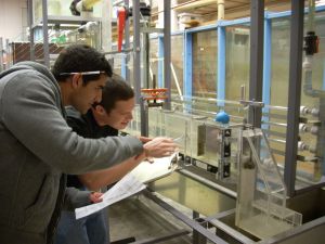 Two students use tools in the department's transparent fliud station