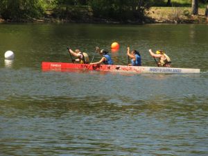 Four students paddle a concrete canoe that they made