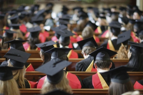 students at commencement in caps and gowns