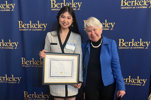An image of Ph.D. candidate Zhe Fu holding her Oski Student Leadership award next to Chancellor Carol Christ in front of a step-and-repeat banner. (Photo Credit: Zhe Fu)